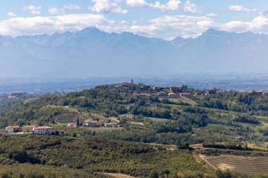 Arka planda Alpler olan Piedmont 'taki Langhe-Roero tepelerinin ve üzüm bağlarının manzarası. İtalya