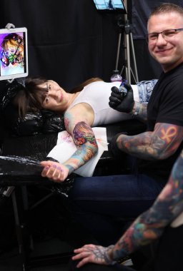 Krakow, Poland -  June 12, 2022: Unidentified  participant at 15th Tattoofest Convention in Cracow. Tattoo artist at work. 