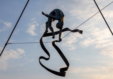 Cracow, Polonya - 2 Mayıs 2022: Krakow 'daki Vistula Nehri üzerindeki Kornatka yaya köprüsünde Jerzy Kedziora tarafından gökyüzü ile su arasında dengeli heykeller