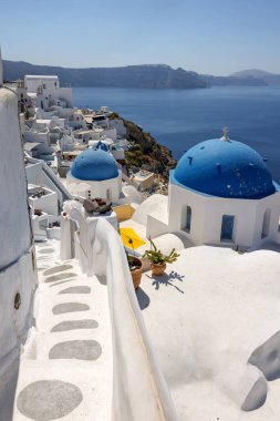 Oia, Santorini, Yunanistan - 3 Temmuz 2021: Yunan ortodoks Hıristiyan kilisesinin mavi kubbesine sahip Oia köyü perspektifinden bakın. Santorini, Yunanistan