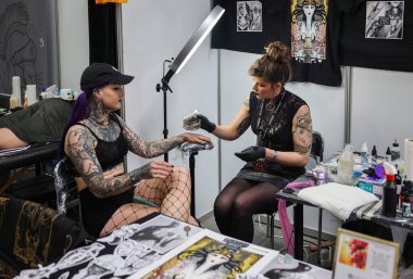 Krakow, Poland -  June 12, 2022: Unidentified  participant at 15th Tattoofest Convention in Cracow. Tattoo artist at work. 
