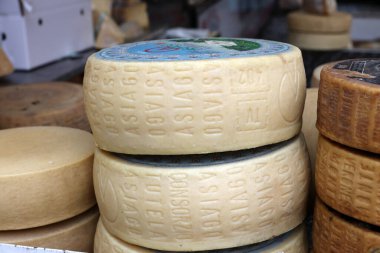 Cremona, İtalya - 7 Eylül 2022: Tüm Asiago peyniri Cremona, Lombardy, İtalya 'daki çiftçi pazarı sırasında bir sokak tezgahında satıldı