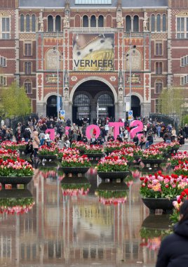 Amsterdam, Hollanda - 21 Nisan 2023: Amsterdam 'daki Rijksmuseum' un önündeki gölette renkli laleler. Hollanda