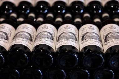Monteriggioni, İtalya - 17 Eylül 2022: Siena yakınlarındaki Monteriggioni 'de bir şarap dükkanında düzenli olarak düzenlenmiş Chianti Classico şarabı şişeleri. İtalya
