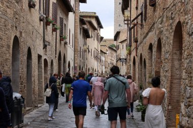 San Gimignano, İtalya - 17 Eylül 2022: Ortaçağ 'ın San Gimingnano kentindeki Via San Giovanni' de turist kalabalığı. Toskana, İtalya