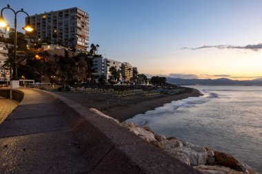 Torremolinos, İspanya - 12 Eylül 2023: gündoğumundan hemen önce Torremolinos 'taki gezinti güvertesi ve Bajondillo plajı. Costa del Sol, İspanya