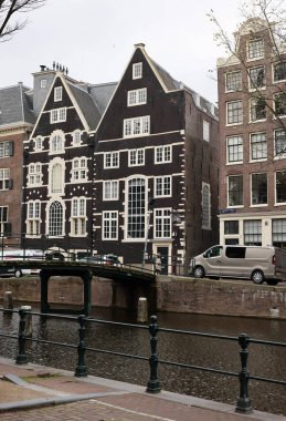 Amsterdam, Hollanda - 21 Nisan 2023: De Wallen - genelev bölgesi olarak adlandırıldı. Eğlence karakteri ile ünlüdür: kanallar boyunca yer alan kardeşler, kahve dükkanları, barlar ve restoranlar.