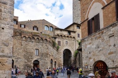 San Gimignano, İtalya - 17 Eylül 2022: Ortaçağ 'ın San Gimingnano kentindeki Via San Giovanni' de turist kalabalığı. Toskana, İtalya