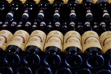 Monteriggioni, İtalya - 17 Eylül 2022: Siena yakınlarındaki Monteriggioni 'de bir şarap dükkanında düzenli olarak düzenlenmiş Chianti Classico şarabı şişeleri. İtalya