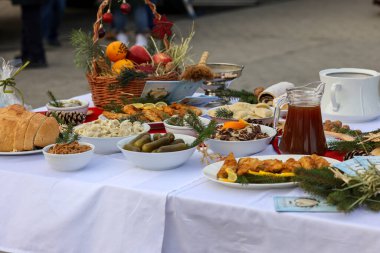 Masadaki Noel yemeği beyaz bir masa örtüsüyle dekore ediliyor.