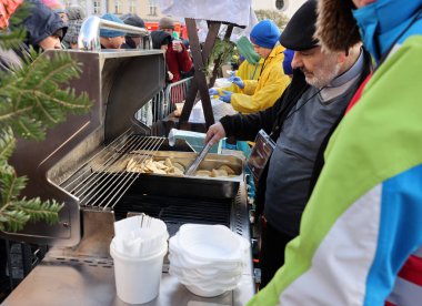 Krakow, Polonya - 17 Aralık 2023: Krakow 'daki ana meydandaki fakir ve evsizler için Noel arifesi. Kosciuszko grubu Krakow 'daki açık havada en büyük arifeyi hazırlıyor