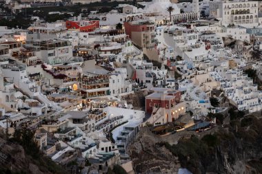 Fira, Santorini, Yunanistan - 27 Haziran 2021: Santorini adasındaki Fira kasabasının restoranları ile aydınlatılmış balkon güverteleri ve terasları. Cyclades, Yunanistan