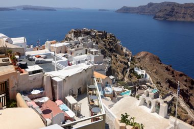 Oia, Santorini, Yunanistan - 3 Temmuz 2021: Yunanistan 'ın Santorini kentindeki Caldera uçurumunun kıyısındaki Agios Nikolaos Kalesi' nin kalıntıları ve Beyazyıkanmış binalar