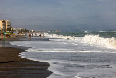 Torremolinos, İspanya - 14 Eylül 2023: Torremolinos, Malaga, Costa del Sol, İspanya 'daki Bajondillo kumsalında köpüklü deniz dalgaları