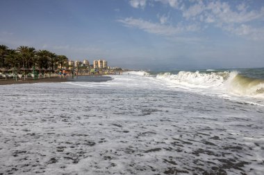 Torremolinos, İspanya - 14 Eylül 2023: Torremolinos, Malaga, Costa del Sol, İspanya 'daki Bajondillo kumsalında köpüklü deniz dalgaları