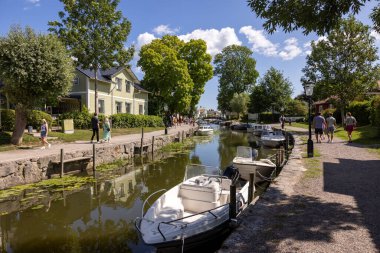 Trosa, İsveç - 29 Temmuz 2023: Sdermanland 'ın Trosa şehrinde demirli zevk tekneleriyle Trosa nehrinin manzarası. İsveç