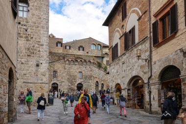 San Gimignano, İtalya - 17 Eylül 2022: Ortaçağ 'ın San Gimingnano kentindeki Via San Giovanni' de turist kalabalığı. Toskana, İtalya