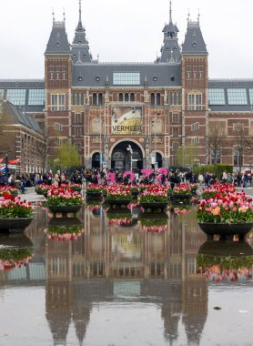 Amsterdam, Hollanda - 21 Nisan 2023: Amsterdam 'daki Rijksmuseum' un önündeki gölette renkli laleler. Hollanda