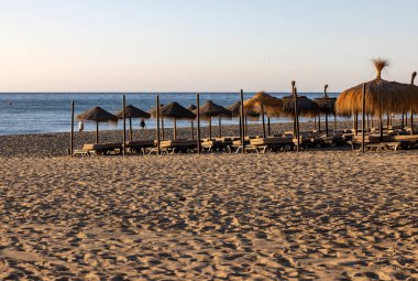 Sabahları Torremolinos 'taki Bajondillo Plajı' nda boş plaj şezlongları. Costa del Sol, İspanya.
