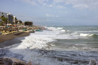 Torremolinos, İspanya - 14 Eylül 2023: Torremolinos, Malaga, Costa del Sol, İspanya 'daki Bajondillo kumsalında köpüklü deniz dalgaları