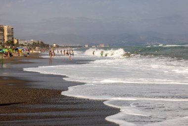 Torremolinos, İspanya - 14 Eylül 2023: Torremolinos, Malaga, Costa del Sol, İspanya 'daki Bajondillo kumsalında köpüklü deniz dalgaları