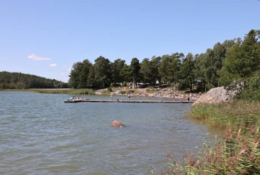 Trosa, İsveç - 29 Temmuz 2023: İnsanlar Sdermanland bölgesindeki Trosa Havsbad plajında, muhteşem takımadalarla çevrili.