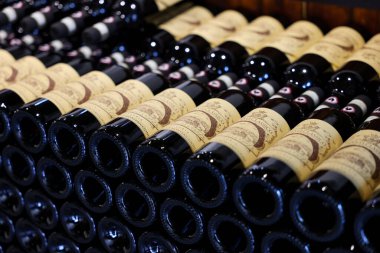 Monteriggioni, İtalya - 17 Eylül 2022: Siena yakınlarındaki Monteriggioni 'de bir şarap dükkanında düzenli olarak düzenlenmiş Chianti Classico şarabı şişeleri. İtalya