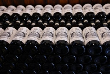 Monteriggioni, İtalya - 17 Eylül 2022: Siena yakınlarındaki Monteriggioni 'de bir şarap dükkanında düzenli olarak düzenlenmiş Chianti Classico şarabı şişeleri. İtalya