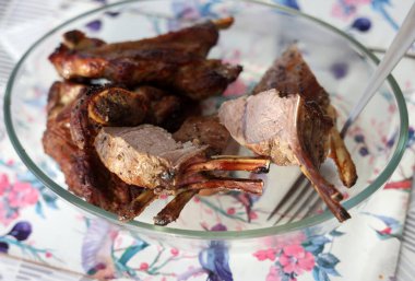 Baked, ready-to-eat saddle of lamb in a glass dish clipart