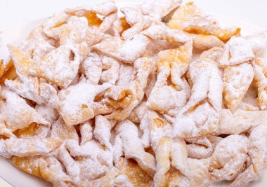 Melek kanatları (Faworki), kekler. Kızarmış tatlı ve üzerine pudra şekeri serpiştirilmiş.