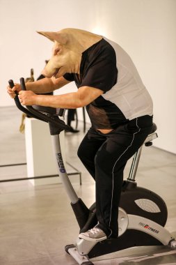 Cracow, Poland - April 25, 2019: Deborah Sengl - all you can lose. Art Installation at Mocak in Krakow. The pig;s head symbolises excessive, unrestrained consumption and cult of the athletic body characteristic of contemporary Western society