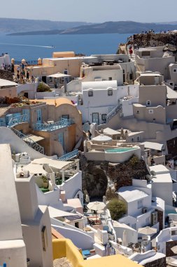 Oia, Santorini, Yunanistan - 3 Temmuz 2021: Yunanistan 'ın Santorini adasındaki Oia' da teras ve havuzlu ve güzel manzaralı bembeyaz evler 