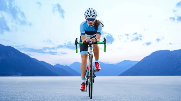 若い女性サイクリスト美しい山の中の道路上のロードバイクに乗る アドベンチャー 健康的なライフスタイルとスポーツのコンセプト ストック写真