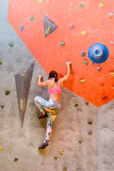 年轻女子攀爬者在攀爬健身房里摇摆不定 极限运动和室内攀爬概念 图库图片