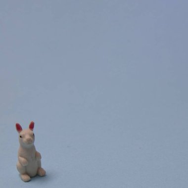 White rabbit in left corner on a blue background with copy space. A minimalist Chinese New Year composition.