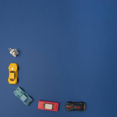 White rabbit in left up corner with cars on a blue background with copy space. A minimalist Chinese New Year composition.