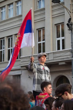 Belgrad 'da düzenlenen bir protestoda Sırp bayrağı sallayan bir çocuk, vatandaşların mevcut hükümetin politikasıyla olan anlaşmazlıklarını dile getiriyor.