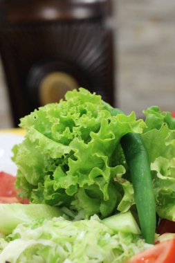 This close-up of a vibrant, fresh salad brimming with a variety of vegetables and lettuce leaves invokes feelings of nourishment, health, and abundance clipart