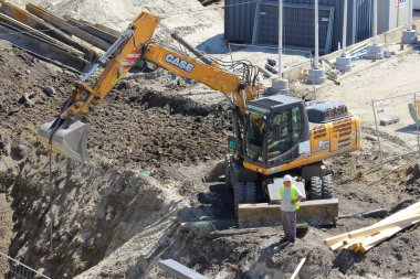 Muazzam bir buldozer kayalık araziyi güçlü bir şekilde tahrip ediyor, açık araziyi dönüştürüyor ve modern inşaat araçlarının dayanıklılığını ve dayanıklılığını gösteriyor.