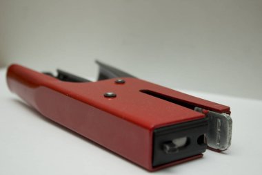 Close-up of a vibrant red stapler on a desk. clipart