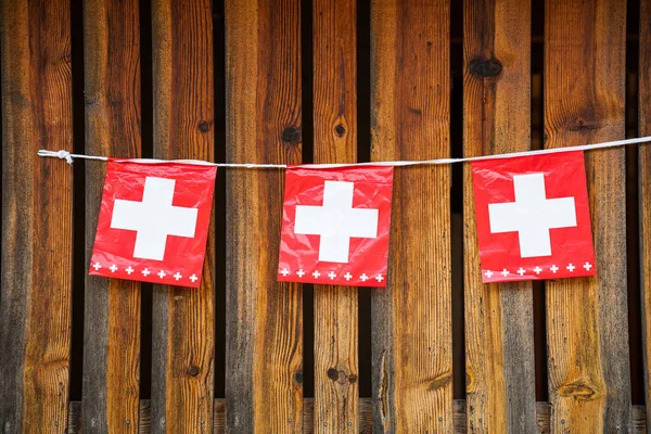 swiss flags with brown wooden background