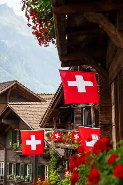 swiss flags with wooden houses in a swiss city