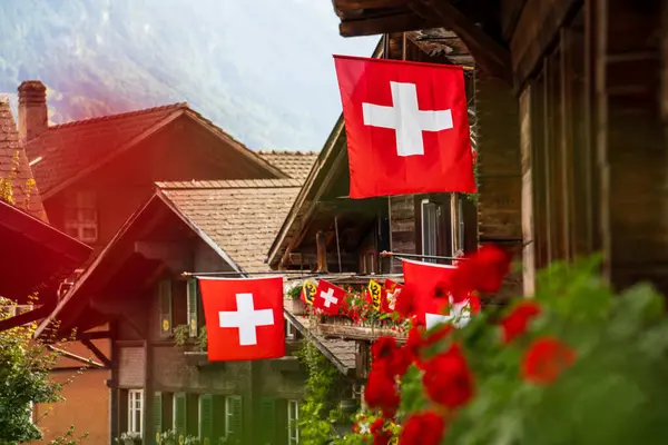 swiss flags with wooden houses in a swiss city