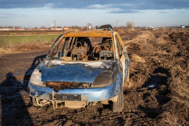 Otoyolun yakınında yanmış bir araba kazası.
