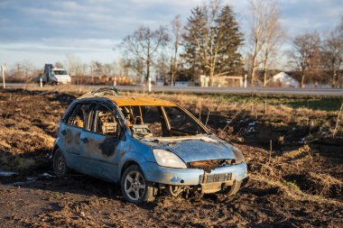 Otoyolun yakınında yanmış bir araba kazası.