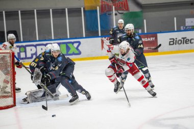 MAC Budapeşte (Budapeşte Jgkorong Akadmia Hokey Kulübü) (mavi) ve Gyergyoi HK (beyaz) buz hokeyi takımları 2 Şubat 2024 tarihinde Budapeşte, Macaristan 'da şampiyonaya katıldılar..