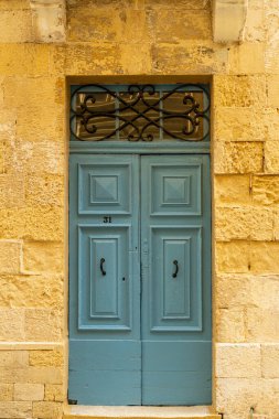 Malta 'da geleneksel ev işleri. Kireçtaşı sarısı tuğlalar ve renkli balkonlar, pencereler