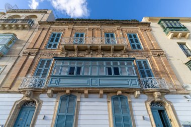Malta 'da geleneksel ev işleri. Kireçtaşı sarısı tuğlalar ve renkli balkonlar, pencereler
