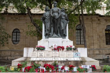 Valletta, Malta - 20 Aralık 2024: 2017 'de öldürülen gazeteci Daphne Caruana Galizia için adalet isteyen Büyük Kuşatma Anıtı' nın tabanına fotoğraflar, mumlar ve mesajlar bırakıldı.