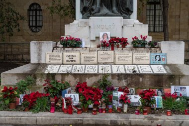 Valletta, Malta - 20 Aralık 2024: 2017 'de öldürülen gazeteci Daphne Caruana Galizia için adalet isteyen Büyük Kuşatma Anıtı' nın tabanına fotoğraflar, mumlar ve mesajlar bırakıldı.